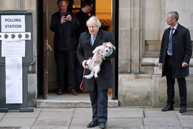 Boris Johnson holds his dog, Dilyn, before casting his vote on election day.