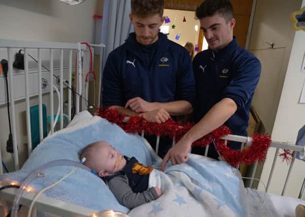 Festive spirit: Yorkshire players Ben Coad and Jordan Thompson during a visit to deliver gifts to youngsters at Leeds General Infirmary on Thursday. Pictures: Ben Wickett