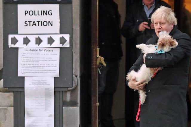 Prime Minister Boris Johnson holds his dog, Dilyn, after casting his vote in the 2019 General Election at Methodist Central Hall, London. Credit: Jonathan Brady/PA Wire