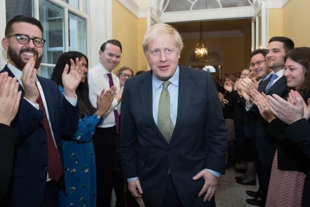Prime Minister Boris Johnson is greeted by staff as he arrives back at 10 Downing Street