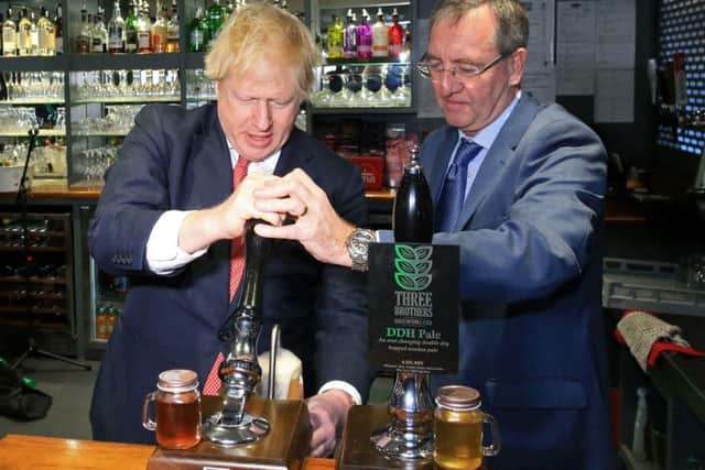 Prime Minister Boris Johnson (left) pulls a pint with newly elected Conservative party MP for Sedgefield, Paul Howell during a visit to Sedgefield Cricket Club in County Durham.