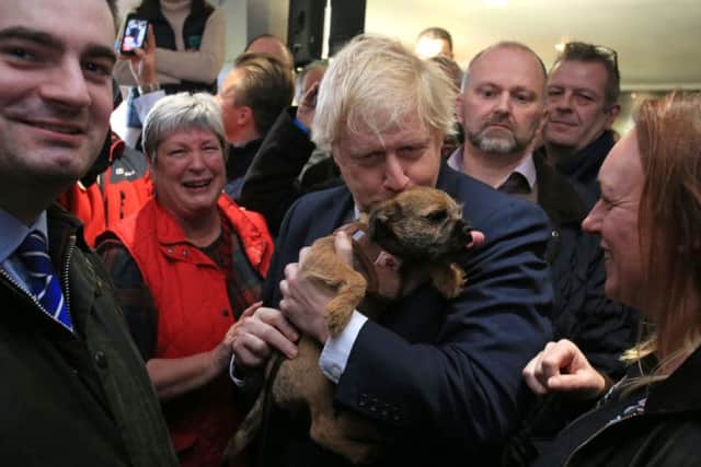 Prime Minister Boris Johnson kisses a supporter's dog during a visit to Sedgefield Cricket Club in County Durham.