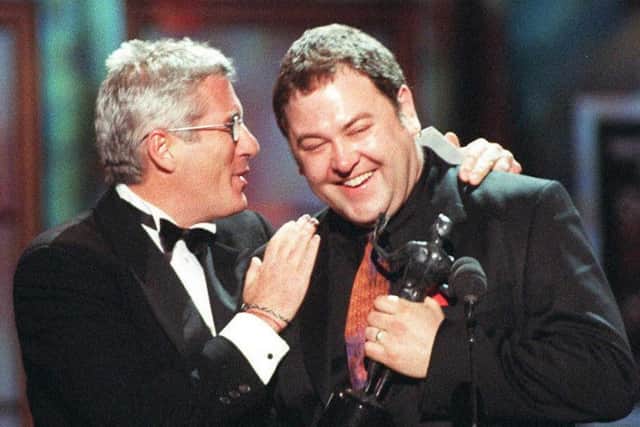 Richard Gere congratulates Mark Addy, who accepted the award for outstanding performance by a cast in a theatrical motion picture for The Full Monty, during the 4th Annual Screen Actor Guild Awards  in Los Angeles.  (Photo credit should read HAL GARB/AFP via Getty Images)
