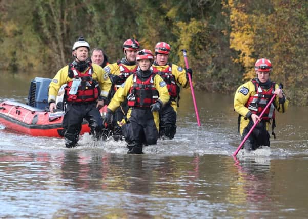 Rescuers pull a boat through Fishlake at the height of last month's floods.