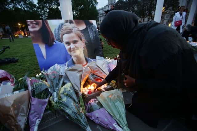 A woman lays flowers at Parliament Square opposite the Palace of Westminster, central London, in tribute to Jo Cox, who died after being shot and stabbed in the street outside her constituency advice surgery in Birstall, West Yorkshire. Picture: Yui Mok/PA Wire