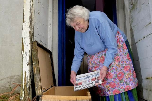 Mary Frank pops a paper into the box outside her home. Picture: Richard Ponter.