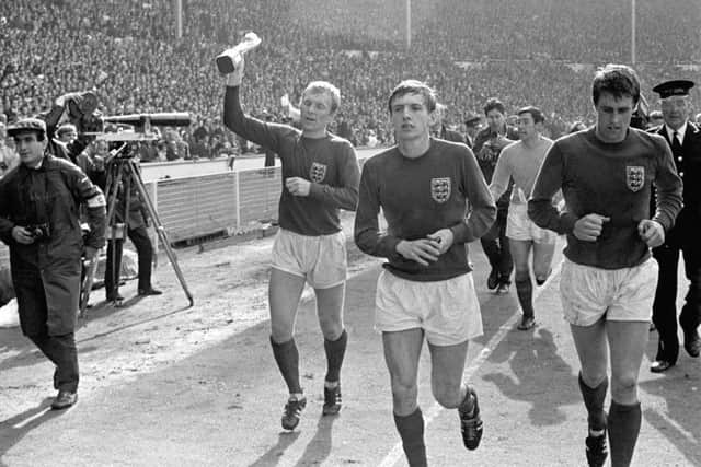 The late Bobby Moore parades the World Cup trophy with Martin Peters and Geoff Hurst.