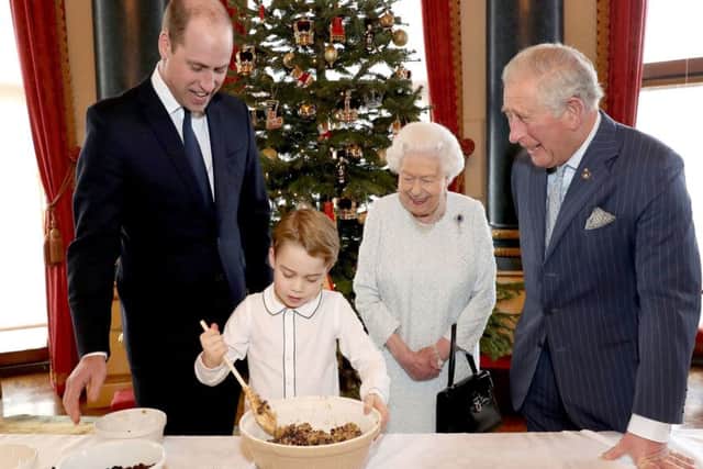 A Buckingham Palace of Queen Elizabeth II, the Prince of Wales, the Duke of Cambridge and Prince George preparing special Christmas puddings in the Music Room at Buckingham Palace  as part of the launch of The Royal British Legion's Together at Christmas initiative.