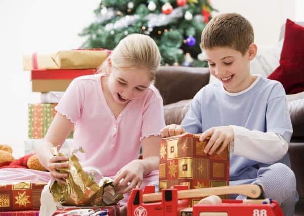 Children unwrapping their Christmas presents. Pic: PA Photo/thinkstockphotos.