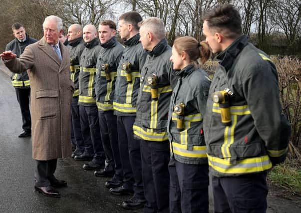 The Prince of Wales meets emergency service personnel during a visit to Fishlake, in South Yorkshire, which was hit by floods last month.