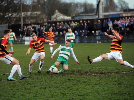 Derby encounter: Nathan Cartman gets a shot away for Farsley Celtic as Bradford Park Avenue players close in.