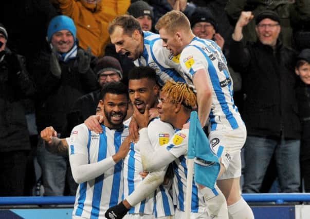 Steve Mounie is mobbed by team-mates after scoring a sumptuous winner for Huddersfield Town