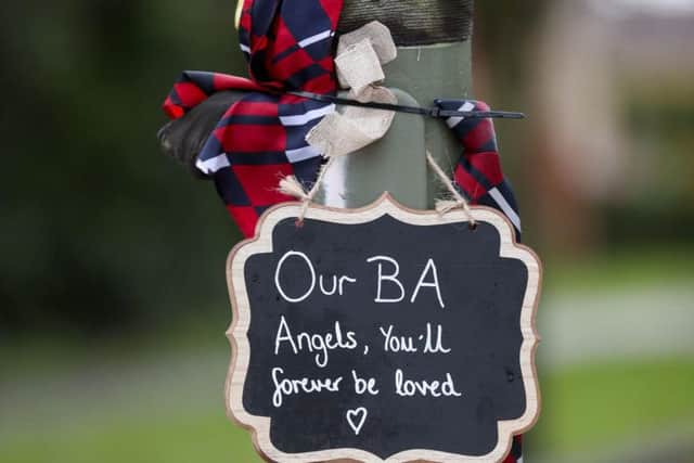 Tributes that have been left at the scene in Stanwell, near London's Heathrow Airport, of a fatal crash on New Year's Eve in which three British Airways cabin crew died. PA Photo.