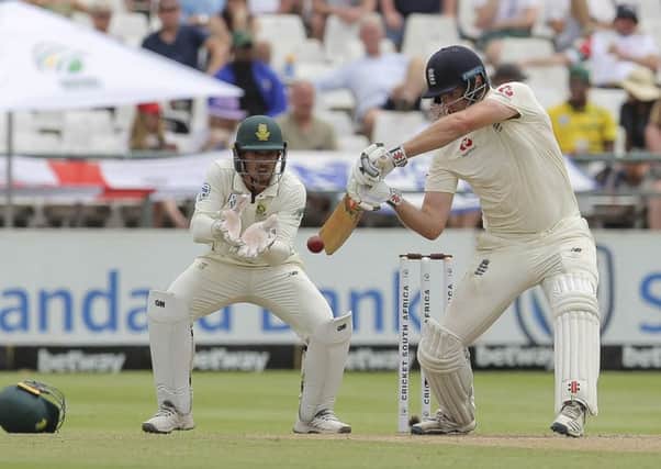 England's batsman Dom Sibley plays a shot as South Africa's wicketkeeper Quinton de Kock watches on.