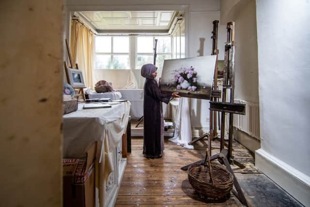 Artist Judith Levin, of Gledhow Hall, Leeds, with  one of her floral oil paintings in her designated studio in her apartment. Picture James Hardisty.