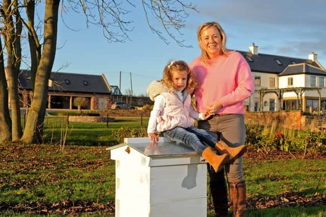 Annabel Makin- Jones, pictured with daughter Jemima on a new beehive in their garden. . Picture Tony Johnson