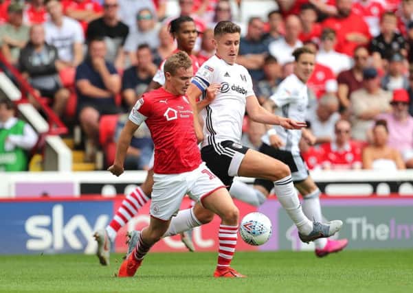Barnsley's Luke Thomas, left, and Fulham's Tom Cairney, right, battle for the ball on the opening day of the season. Picture: Richard Sellers/PA