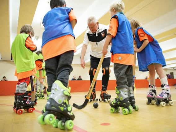 Keith Whitton, chairman of Sheffield Wildcats Rink Hockey Club, coaching some of the youngsters.
