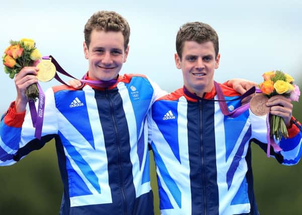 Great Britain's Alistair Brownlee celebrates with his gold medal and Jonathan Brownlee (right) celebrates with his bronze medal, after the Men's Triathlon on the eleventh day of the London 2012 Olympics.