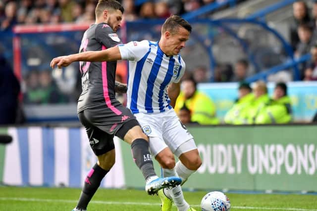 Leeds United's Mateusz Klich and Huddersfield Town's Jonathan Hogg, who will be missing today (Picture: PA)