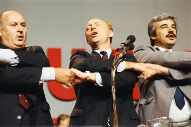 Welsh politician and Labour Party leader, Neil Kinnock (centre), singing with Party bureaucrats Jim Mortimer (left) and Larry Whitty (right) at the Labour Party Conference in Blackpool, October 1985. (Photo by Fox Photos/Hulton Archive/Getty Images)
