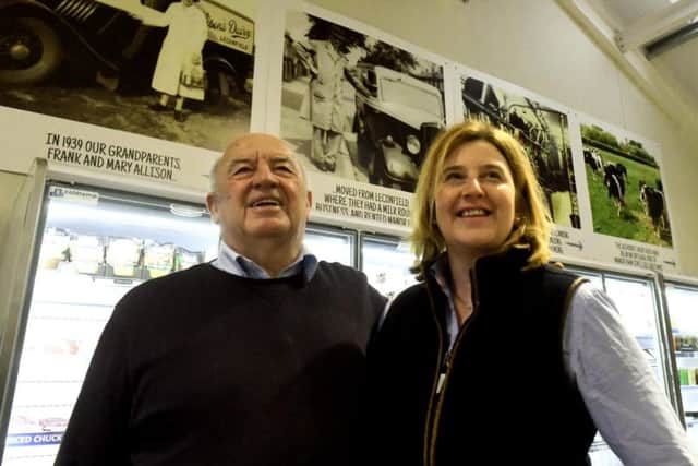 Helen Stones with her father Adrian Fry in the Farm Shop at Cranswick. The background shows historic family photos from left: Helen's Grandmother Mary Allison on the milk round business in 1939, Frank Allison in 1939, Adrian Fry on the farm in 1974 and The Althorpe Dairy Herd.