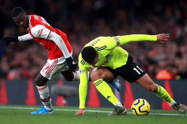 Arsenal's Nicolas Pepe (left) and Sheffield United's Callum Robinson battle for the ball (Picture: PA)