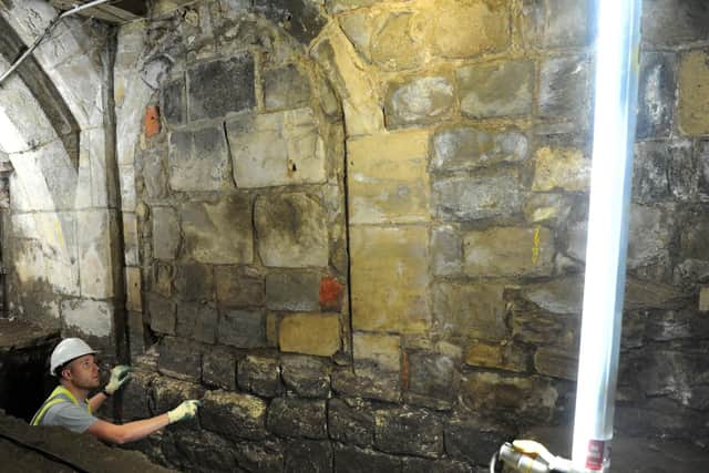 A archaeologist examines a window that was blocked up in the 1600s in Common Hall Lane