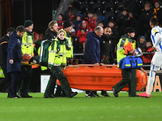 Huddersfield Town goalkeeper Kamil Grabara is stretchered off in his side's game at Hull City on Tuesday night. PICTURE; JONATHAN GAWTHORPE.