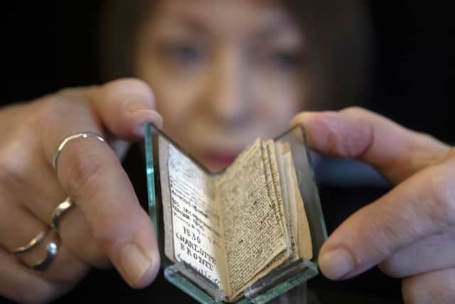Principal curator Ann Dinsdale holds a rare 'little book' written by Charlotte Bronte following its return home to the Bronte Parsonage Museum, in Haworth