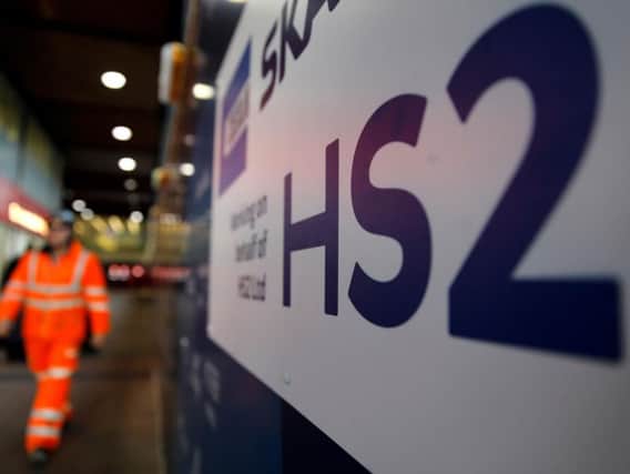 A worker walks past a sign outside a construction site for a section of Britain's HS2 high-speed railway project. Photo: Getty