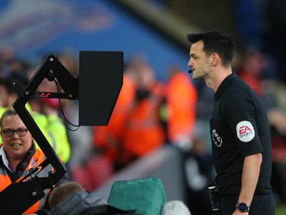Andy Madley consults the monitor before downgrading the red card he showed Crystal Palace's Joel Ward