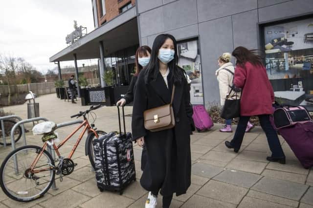 Two people leave the StayCity building in York, where the people with confirmed cases of coronavirus had been staying. Credit: PA.