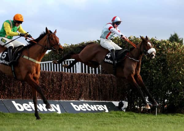 itchy Fett and Gavin Sheehan (right) clear the last in the Scilly Isle Novices Chase at Sandown alongside Danny Cook on Midnight Shadow (left).