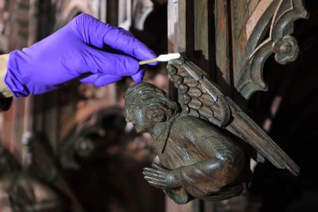 Tristram Bainbridge working with a tiny brush on one of the angels in the Medieval quire. Picture Gerard Binks