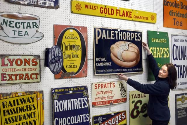 Becky Brigham, an auction room administrator at Spicers of Driffield, arranging metal advertising signs in the Bridlington Station Buffet sale Picture: Gary Longbottom