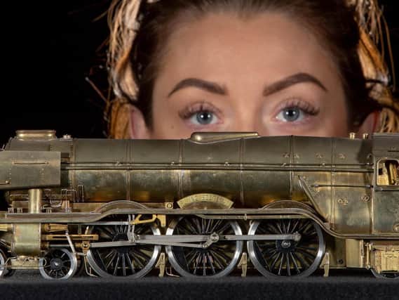 Becky Brigham, an auction room administrator, with a working electric model of the Flying Scotsman made of brass. Pictures: Charlotte Graham