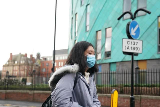 A woman wearing a face mask outside the Royal Victoria Infirmary in Newcastle, where two patients are being treated for coronavirus