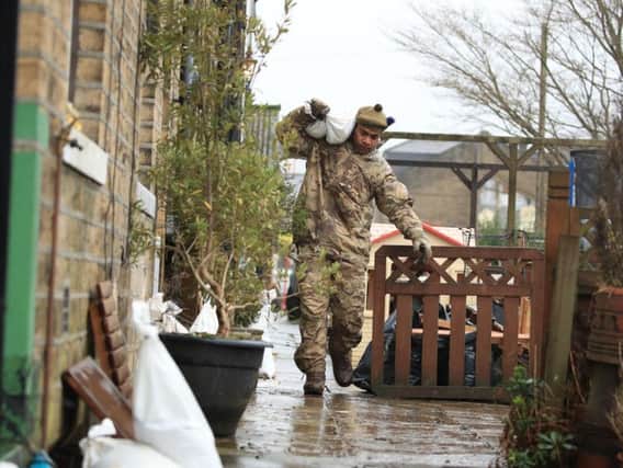 A soldier from The Highlanders, 4th Battalion, the Royal Regiment of Scotland in Mytholmroyd assisting with flood defences. PIC: PA