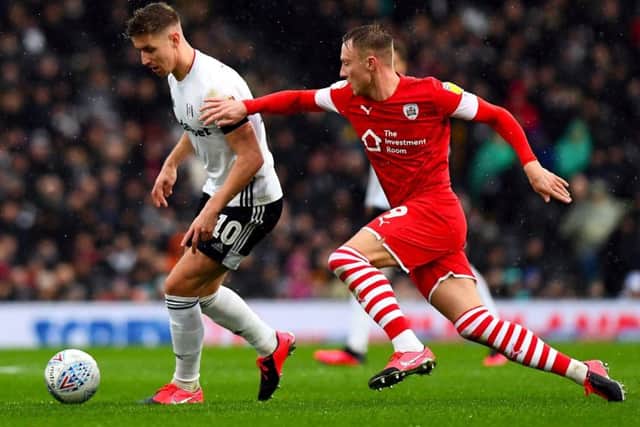 Fulham's Tom Cairney (left) and Barnsley's goalscorer Cauley Woodrow (Picture: PA)