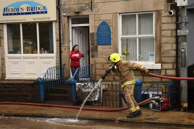 Members of the Fire Brigade help with the clean up efforts in Hebden Bridge, after flooding brought by Storm Ciara. Photo by OLI SCARFF/AFP via Getty Images