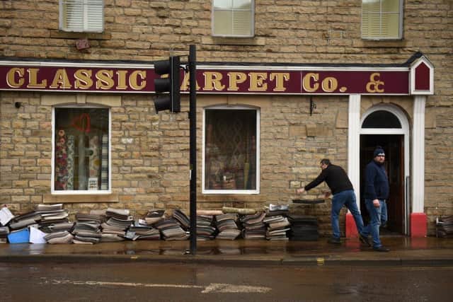 People help to clear up at a business in Hebden Bridge. Photo by OLI SCARFF/AFP via Getty Images