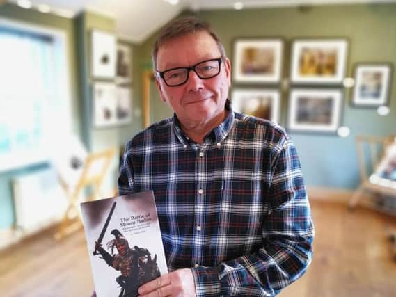 Historian and author Alistair Hall with his book on King Arthur.