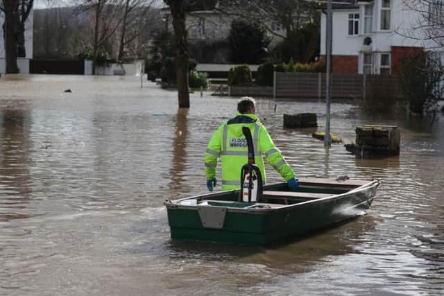 A Flood Warden delivering a vacuum cleaner through flooded streets in Hereford, in the aftermath of Storm Dennis. Picture: Steve Parsons/PA Wire