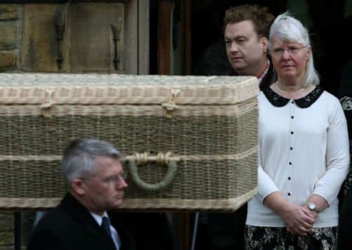 Maureen Greaves watches her husband Alan's coffin leave St Saviour's Church in High Green, Sheffield