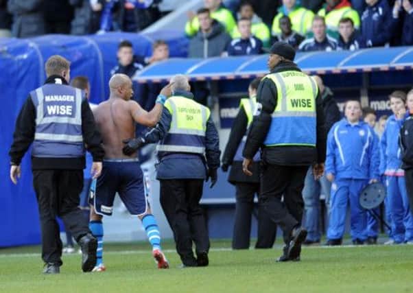 El-Hadji Diouf gestures to Millwall fans as he is led from the pitch after the match.