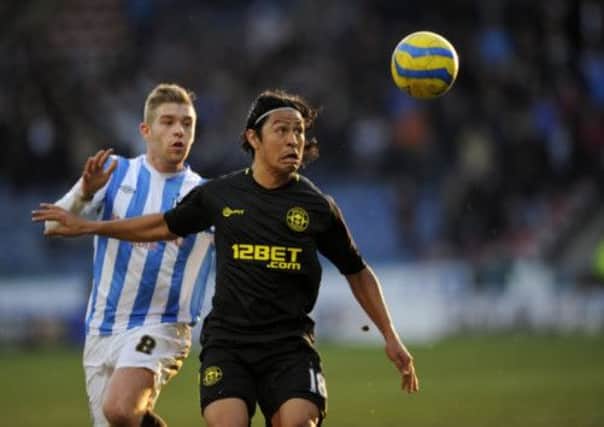 Wigan Athletic's Roger Espinoza is challenged by Huddersfield Town's Adam Clayton (left). (Picture: Jon Buckle/PA Wire).