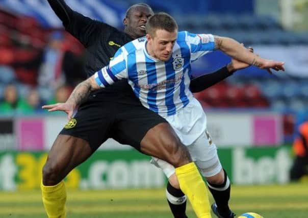 Town's Peter Clarke battles with Wigan's Arouna Kone.