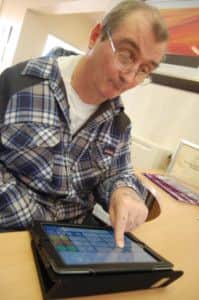 Kevin Beverley using an iPad at the Carlton daycare centre in Barnsley.