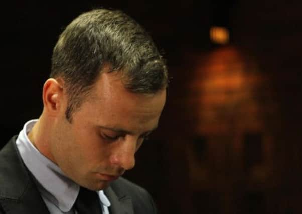 Olympic athlete Oscar Pistorius stands inside the court as a police officer looks on during his bail hearing at the magistrate court in Pretoria, South Africa.